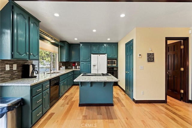 918 Sandalwood Dr, Lake Arrowhead, CA 92352 - kitchen featuring black appliances, light wood-type flooring, decorative backsplash, a center island, and recessed lighting