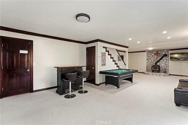 recreation room with a wood stove, light carpet, bar area, ornamental molding, and pool table