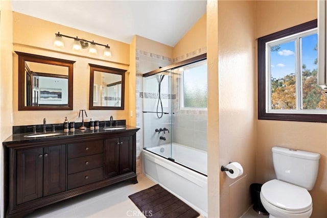 full bathroom featuring tile patterned floors, vanity, shower / bath combination with glass door, toilet, and lofted ceiling