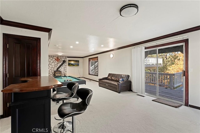 interior space with a wood stove, crown molding, light colored carpet, and pool table