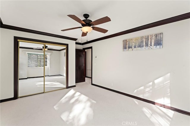 unfurnished bedroom featuring ceiling fan, crown molding, and a closet