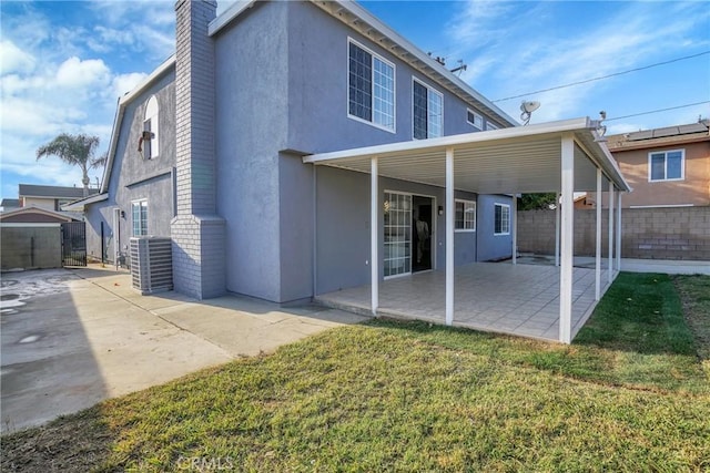 rear view of property with a yard and a patio