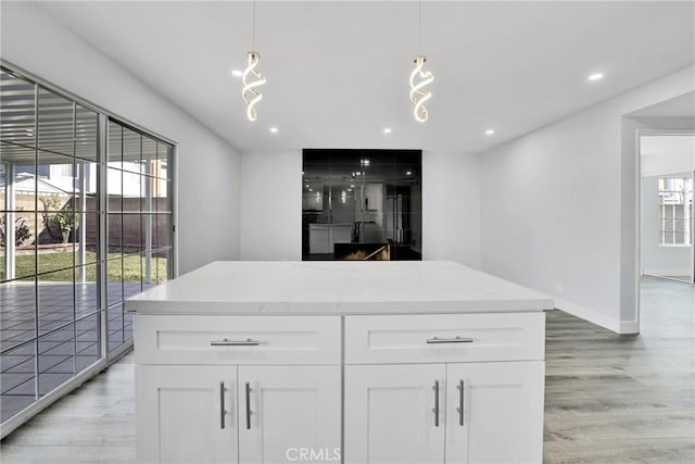 kitchen with white cabinets, hanging light fixtures, and a healthy amount of sunlight