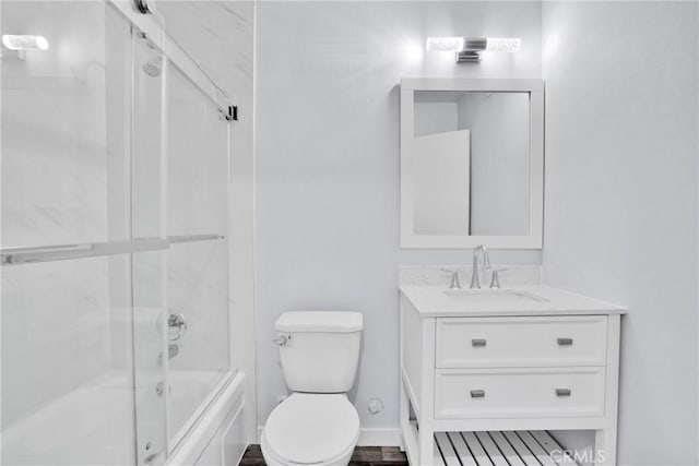 full bathroom featuring shower / bath combination with glass door, vanity, and toilet