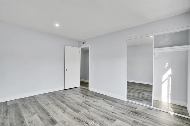 unfurnished bedroom with light hardwood / wood-style floors and a closet