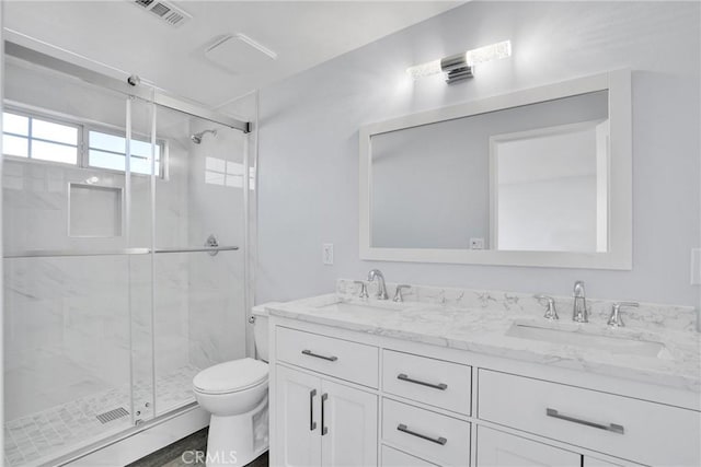 bathroom featuring vanity, toilet, and an enclosed shower