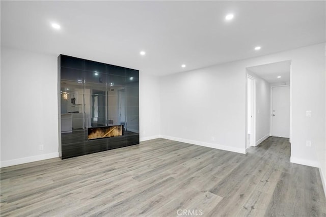 unfurnished living room with a fireplace and light hardwood / wood-style flooring