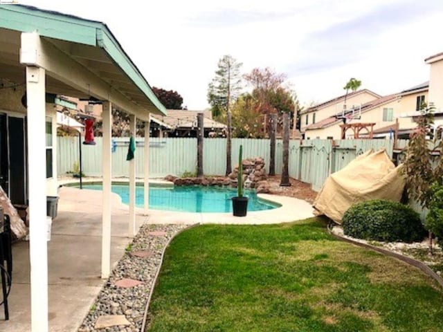 view of pool featuring a lawn and a patio area