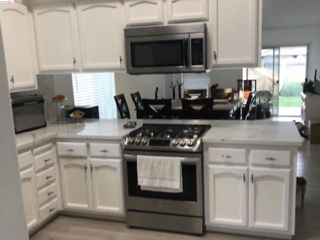 kitchen with white cabinetry and appliances with stainless steel finishes