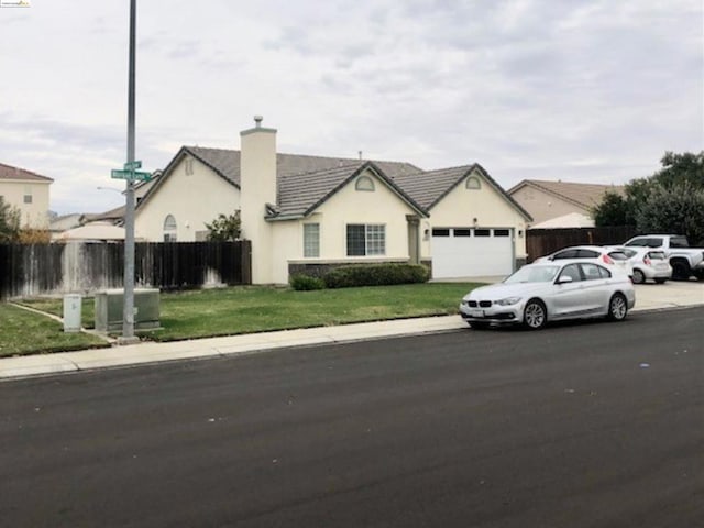 ranch-style house featuring a front yard and a garage