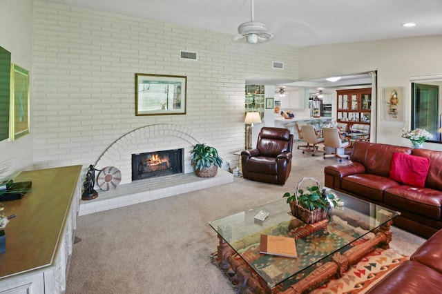 living room featuring light carpet, a brick fireplace, ceiling fan, and brick wall