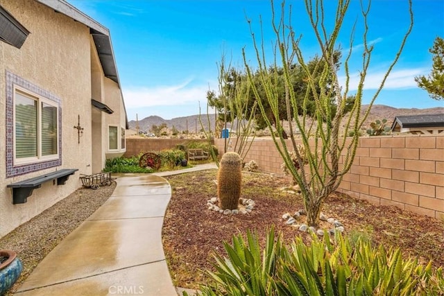 view of yard featuring a mountain view and a fenced backyard