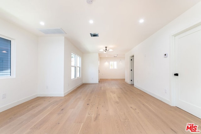 empty room with ceiling fan and light wood-type flooring