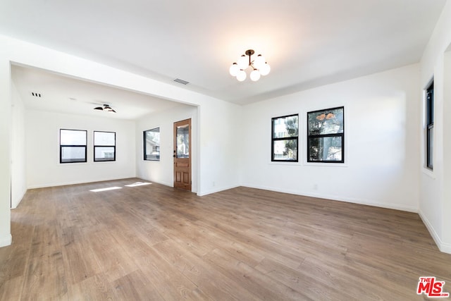 unfurnished room featuring light hardwood / wood-style flooring and a notable chandelier