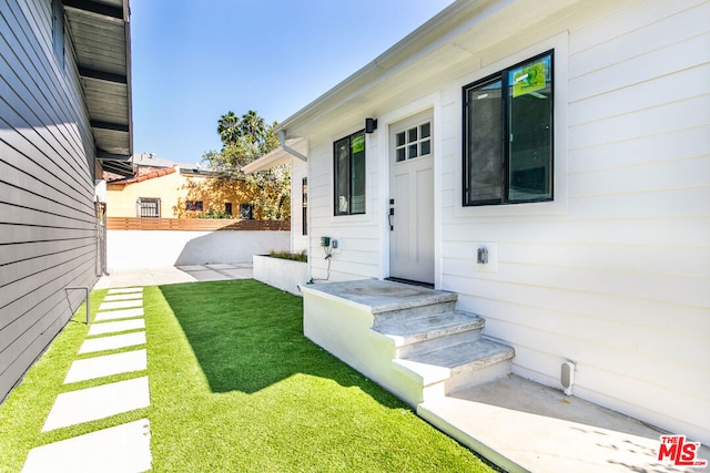 property entrance with a lawn