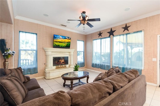 tiled living room with ceiling fan, a healthy amount of sunlight, and ornamental molding