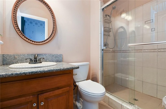 bathroom with vanity, toilet, and a shower with shower door