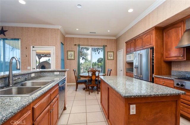 kitchen featuring crown molding, sink, an island with sink, light stone counters, and stainless steel appliances