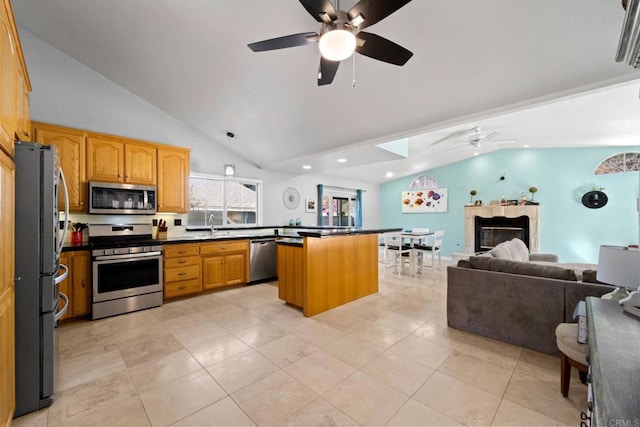 kitchen with high vaulted ceiling, light tile patterned floors, appliances with stainless steel finishes, and a center island