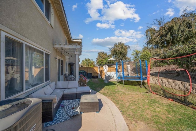 view of yard with an outdoor living space, a patio area, a trampoline, and central air condition unit