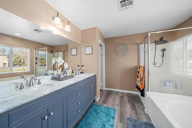 bathroom with vanity, hardwood / wood-style floors, and plus walk in shower