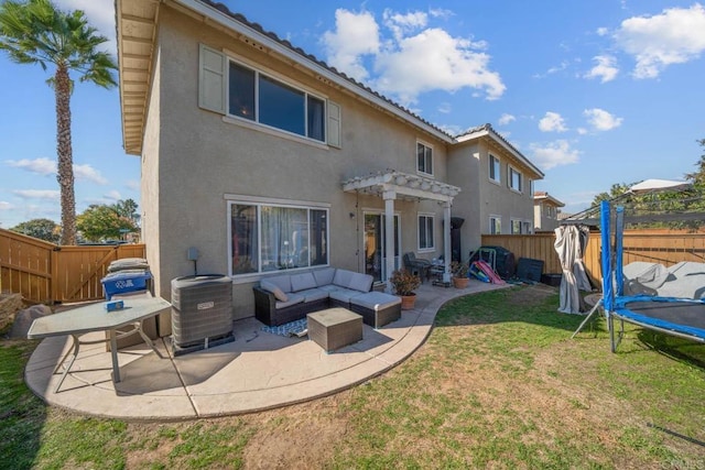 back of property featuring a lawn, a trampoline, an outdoor hangout area, central AC unit, and a patio