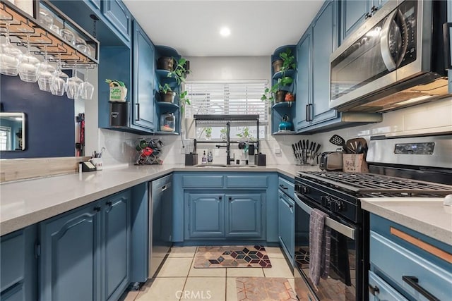 kitchen with stainless steel appliances, blue cabinetry, and sink