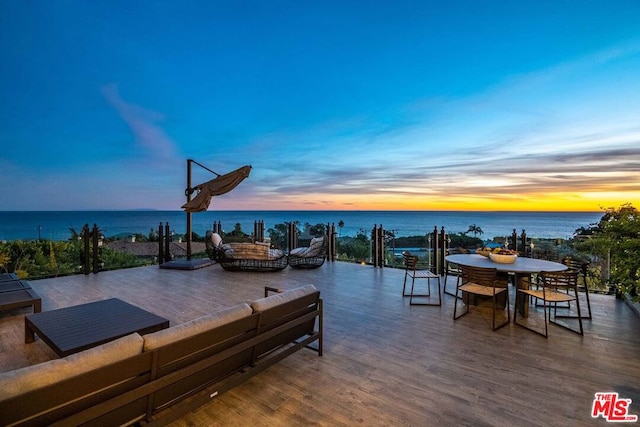 patio terrace at dusk featuring a water view