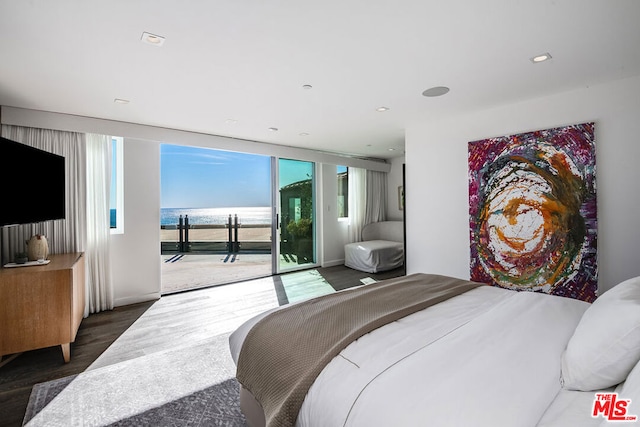 bedroom featuring access to exterior, a water view, and dark hardwood / wood-style floors