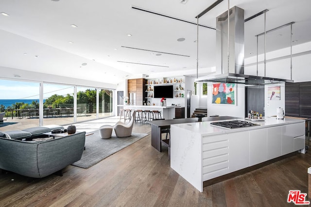 kitchen with white cabinets, island range hood, dark hardwood / wood-style flooring, and stainless steel gas cooktop