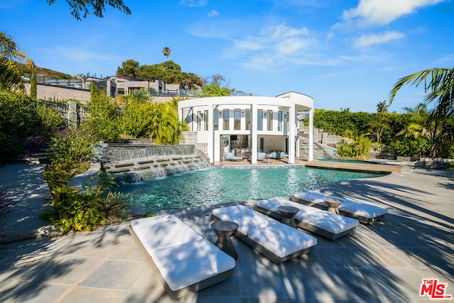 view of swimming pool featuring pool water feature and a patio area