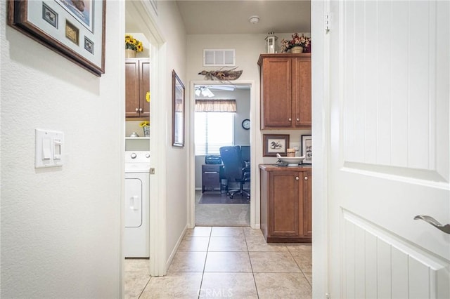 hallway with light tile patterned floors and washer / clothes dryer