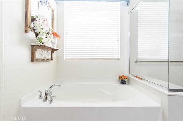 bathroom with a washtub and a healthy amount of sunlight