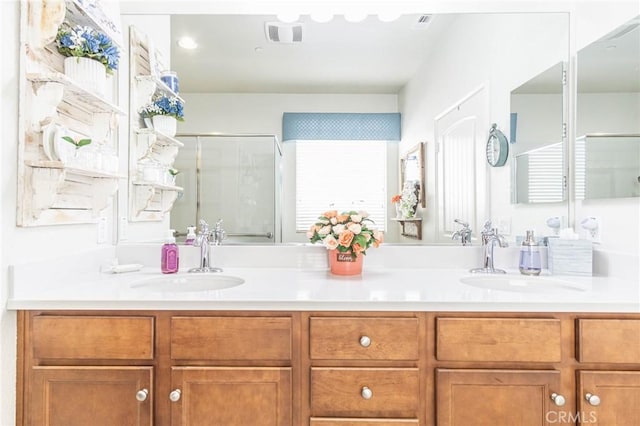 bathroom featuring a shower with door and vanity