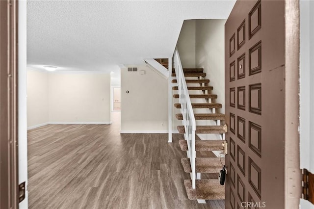 foyer entrance with a textured ceiling and dark hardwood / wood-style flooring