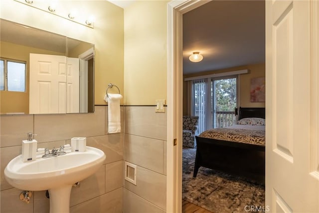 bathroom featuring hardwood / wood-style flooring and tile walls