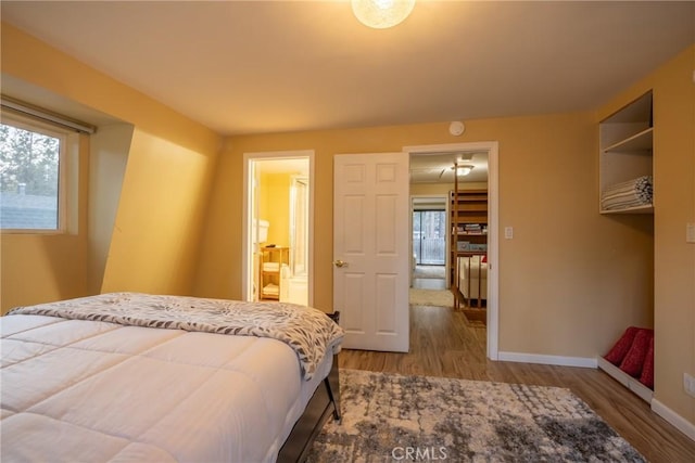 bedroom with ensuite bathroom and wood-type flooring