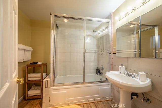 bathroom featuring enclosed tub / shower combo and hardwood / wood-style flooring