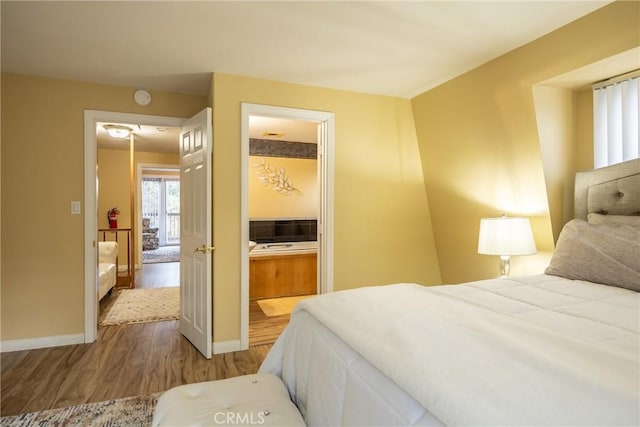 bedroom featuring hardwood / wood-style floors, ensuite bathroom, and a closet