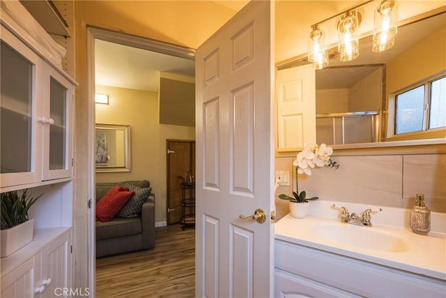 bathroom featuring walk in shower, vanity, and hardwood / wood-style flooring