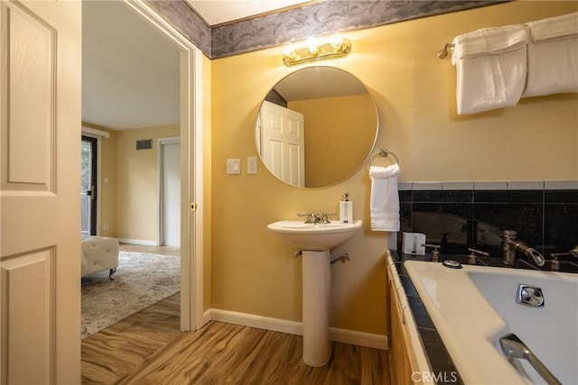 bathroom featuring decorative backsplash and hardwood / wood-style flooring