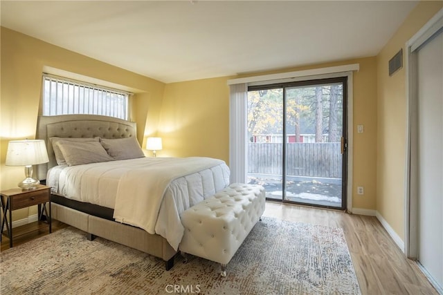 bedroom featuring light wood-type flooring and access to outside