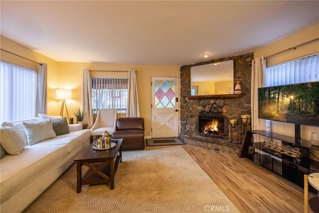 living room featuring a stone fireplace and hardwood / wood-style floors