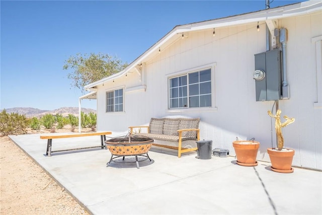 view of patio / terrace featuring a mountain view and an outdoor living space with a fire pit