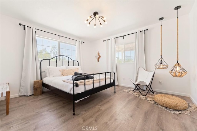 bedroom featuring hardwood / wood-style floors and an inviting chandelier