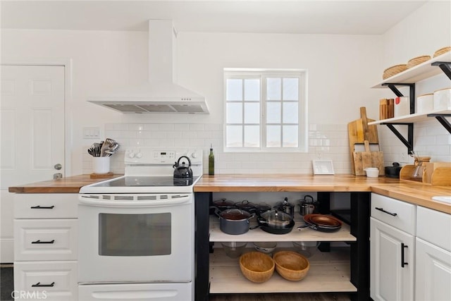 kitchen featuring wood counters, white cabinets, white electric stove, wall chimney exhaust hood, and decorative backsplash