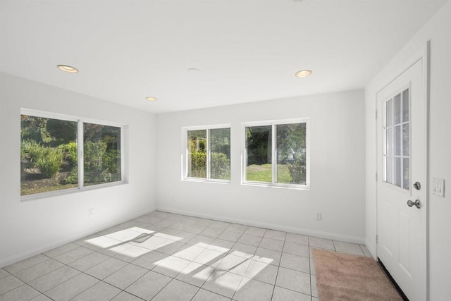 spare room featuring plenty of natural light and light tile patterned flooring