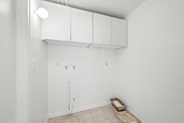 clothes washing area featuring gas dryer hookup, hookup for a washing machine, light tile patterned flooring, and cabinets