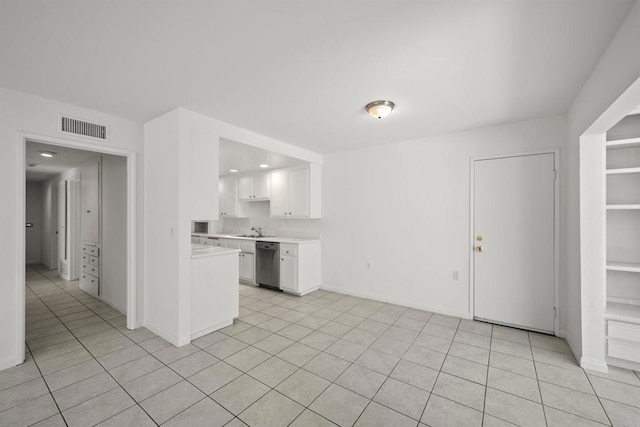 kitchen with white cabinetry, dishwasher, light tile patterned flooring, and sink