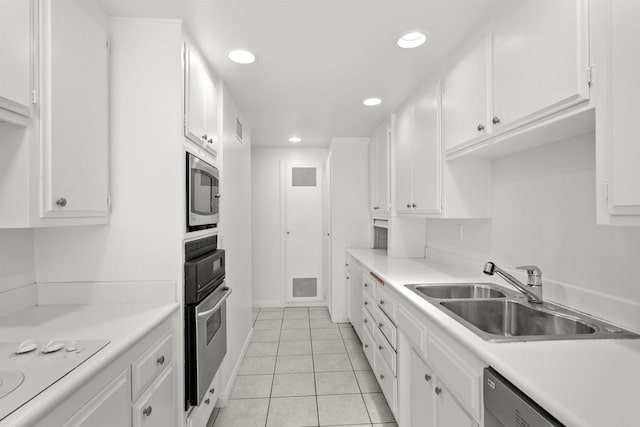 kitchen with light tile patterned floors, stainless steel appliances, white cabinetry, and sink